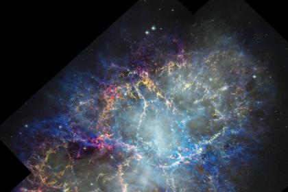 Colorful nebula in space with a white haze throughout that is more concentrated in the center with a rippling effect. Colorful gas filaments appear to splash outward from the nebula center, colored yellow, magenta, and blue. A faint black border with right angles at the corners of the images show where the telescope’s field of view stops. Small white stars dot the background.