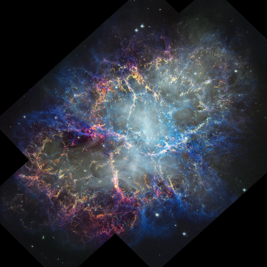 Colorful nebula in space with a white haze throughout that is more concentrated in the center with a rippling effect. Colorful gas filaments appear to splash outward from the nebula center, colored yellow, magenta, and blue. A faint black border with right angles at the corners of the images show where the telescope’s field of view stops. Small white stars dot the background.