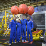 NASA astronauts Reid Wiseman, commander; left, Christina Koch, mission specialist; CSA (Canadian Space Agency) astronaut Jeremy Hansen, mission specialist; and NASA astronaut Victor Glover, Artemis II pilot, right, pose for a group photo after viewing the Orion spacecraft in the well deck of USS John P. Murtha, Saturday, April 11, 2026, in the Pacific Ocean off the coast of California. The quartet splashed down Friday, April 10 at 5:07 p.m. PDT (8:07p.m. EDT).