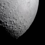 Part of the Moon stands out against the blackness of space. Its surface is marked with many craters of different sizes. The craters are mostly on the left and bottom. The upper right portion of the Moon's surface is much smoother.