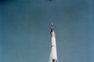 In this view from below, the Mercury-Redstone 3 space vehicle shines in the morning sun as it soars into the blue sky above Cape Canaveral, Florida.