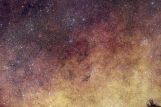 This view of the heart of the Milky Way Galaxy features dense yellow clouds and millions of stars.