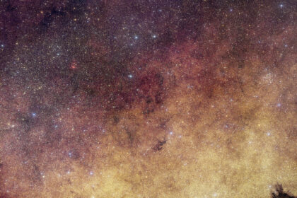 This view of the heart of the Milky Way Galaxy features dense yellow clouds and millions of stars.