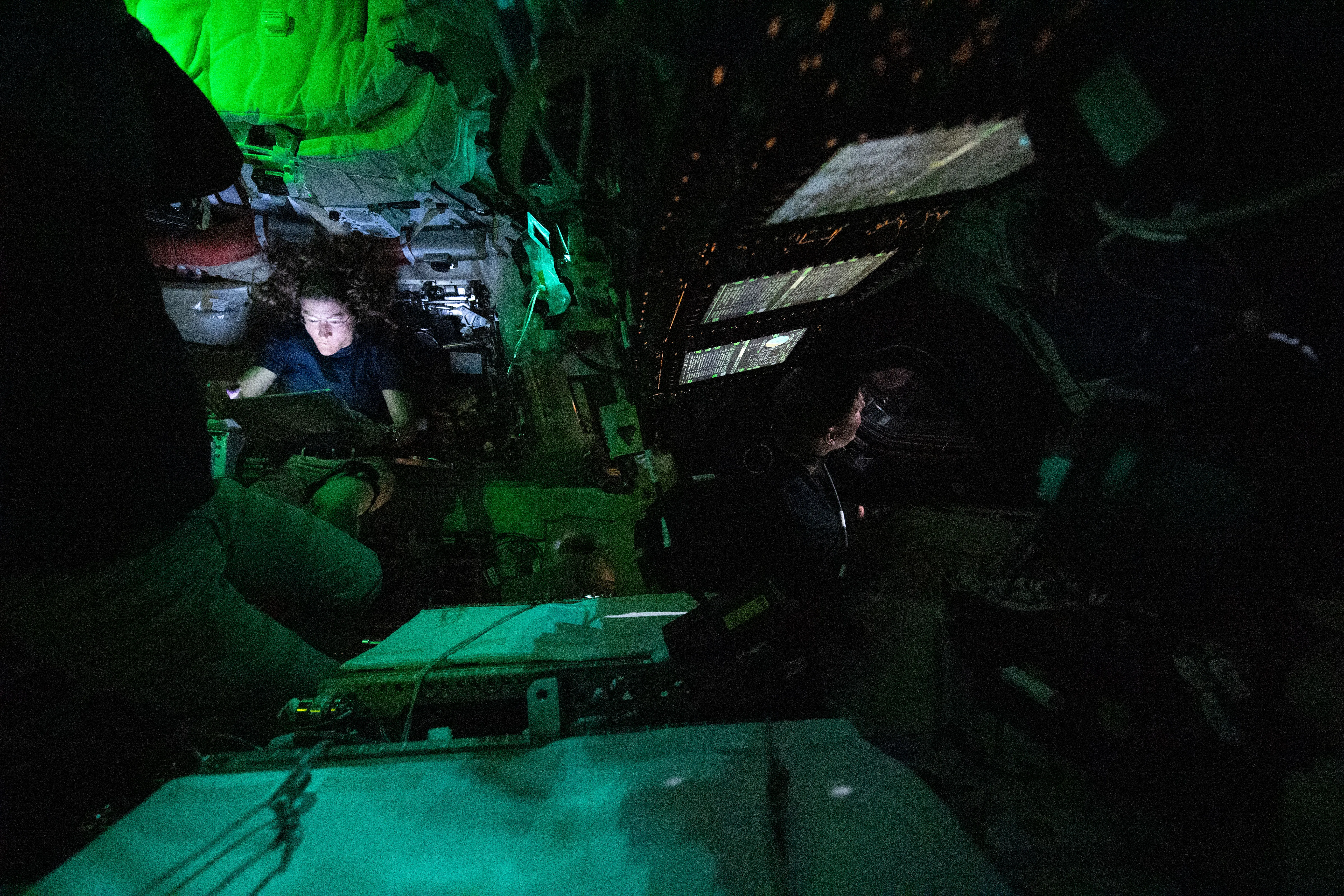 Orion uzay aracının içinde aydınlatılmış NASA astronotu Christina Koch ve CSA astronotu Jeremy Hansen