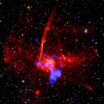 Set against a backdrop packed with distant stars and other specks of light are two distinct, overlapping clouds. The larger, visually dominant cloud, is red and multifaceted. It has an irregular shape, and features patches of different textures, including pockets that resemble wispy smoke, tangles of faint red veins, and clear streaking lines. This large cloud of expanding gas represents radio data from the MeerKAT telescope in South Africa. Overlapping with that red cloud is a cloudy blue blob representing X-ray data from NASA's Chandra X-ray Observatory and ESA's XMM-Newton.