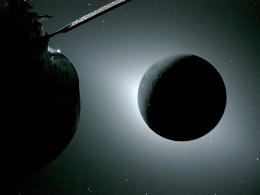The Moon is backlit by the Sun. Earth is reflecting sunlight at the left edge of the Moon, which is slightly brighter than the rest of the disk; this light reveals a small sliver of the Moon's gray surface. The bright spot visible just below the Moon’s bottom right edge is Saturn. Beyond that, the bright spot at the right edge of the image is Mars. The Orion spacecraft is visible in the foreground on the left.